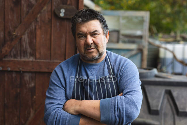 Portrait of caucasian male gardener with crossed hands looking at camera at garden centre. specialist working at bonsai plant nursery, independent horticulture business. — Stock Photo