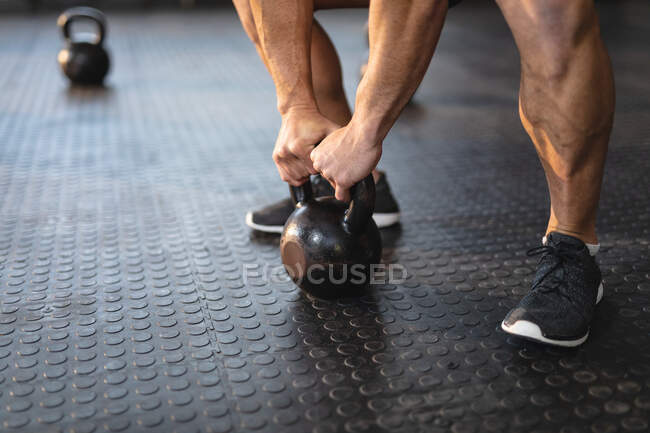 Homem forte exercitando-se no ginásio, levantando pesos. treinamento cruzado de força e aptidão para boxe. — Fotografia de Stock