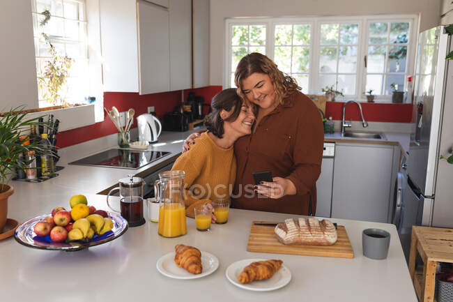 Coppia lesbica sorridente e preparare la colazione in cucina. stile di vita domestico, trascorrere il tempo libero a casa. — Foto stock