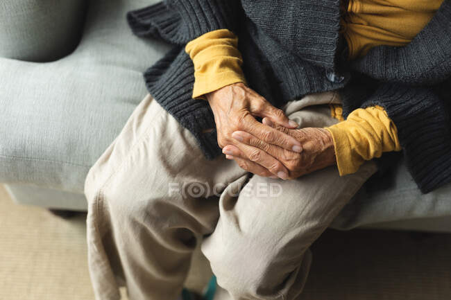 Parte média da mulher idosa em casa sentada no sofá. estilo de vida sênior, passar tempo em casa. — Fotografia de Stock