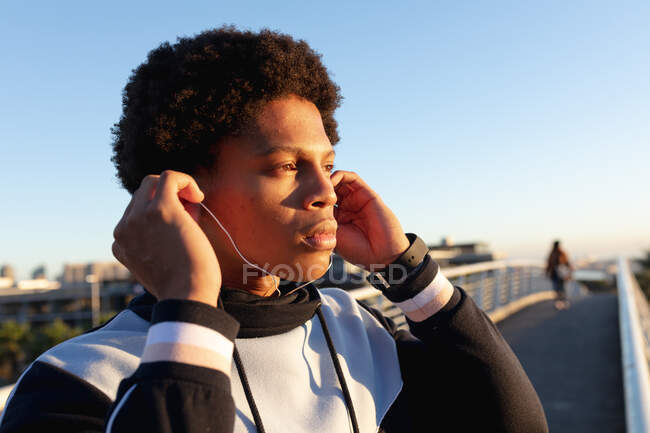Apto afro-americano exercitando-se na cidade usando fones de ouvido na rua. fitness e estilo de vida urbano ativo ao ar livre. — Fotografia de Stock