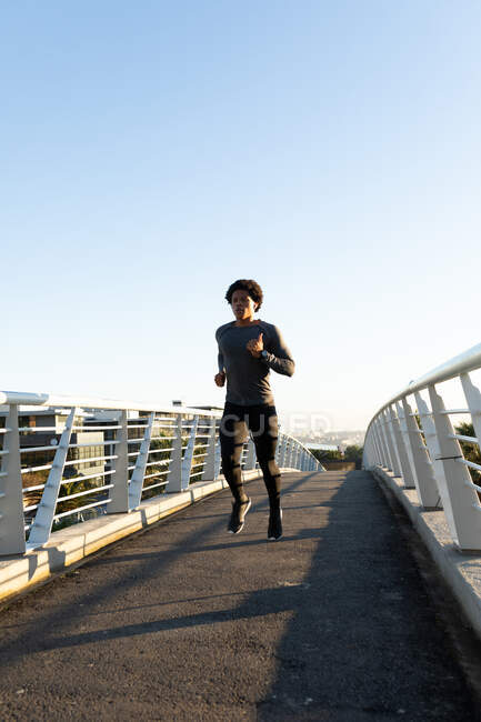 Ajuste o homem americano africano que exercita-se na cidade que funciona na rua. fitness e estilo de vida urbano ativo ao ar livre. — Fotografia de Stock