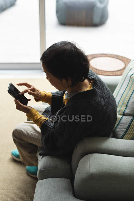Senior asian woman at home using smartphone. senior lifestyle, technology, spending time at home. — Stock Photo