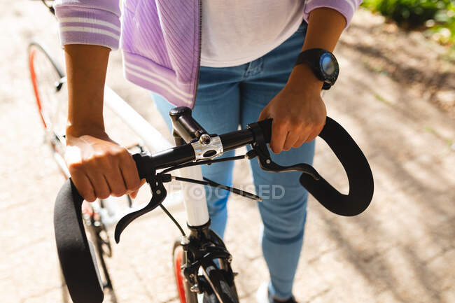 Frau radelt Fahrrad im sonnigen Park. Unabhängige junge Frau in der Stadt unterwegs. — Stockfoto