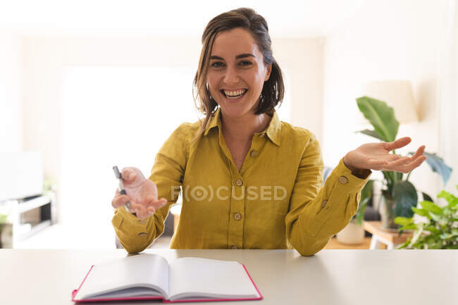 Retrato de una mujer caucásica haciendo una videollamada, hablando y sonriendo. estilo de vida doméstico, pasar tiempo libre en casa. - foto de stock