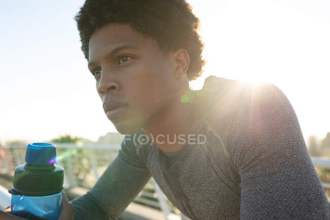 Подходящий африканский американец, тренирующийся в городе, отдыхающий и пьющий воду. фитнес и активный городской уличный образ жизни. — стоковое фото
