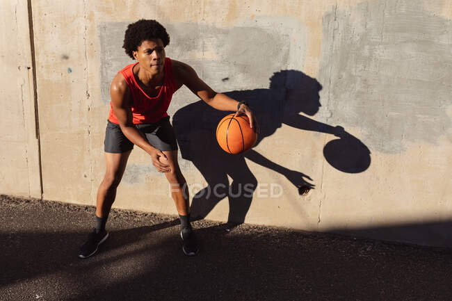 Подходящий африканский американец, тренирующийся в городе, играющий в баскетбол на улице. фитнес и активный городской уличный образ жизни. — стоковое фото