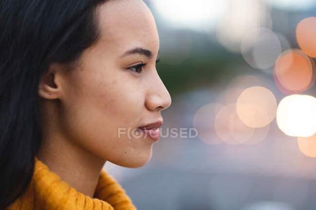 Mujer asiática sonriente mirando hacia otro lado en la calle. mujer joven independiente fuera y alrededor de la ciudad. - foto de stock
