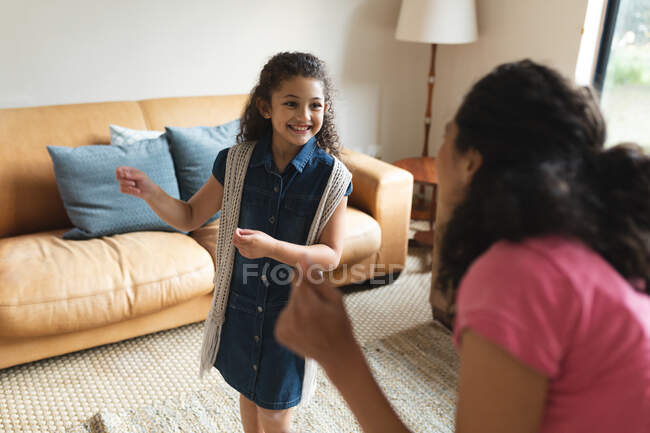 Glückliche gemischte Rasse Mutter und Tochter tanzen im Wohnzimmer. Lebensstil und hochwertige Zeit zu Hause verbringen. — Stockfoto