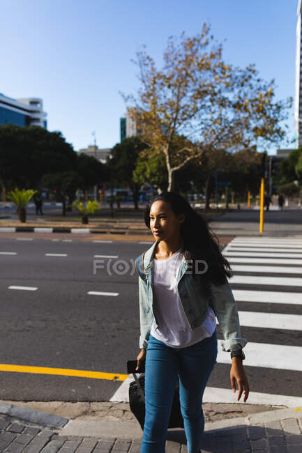 Asian woman crossing road with suitcase. independent young woman out and about in the city. — Stock Photo