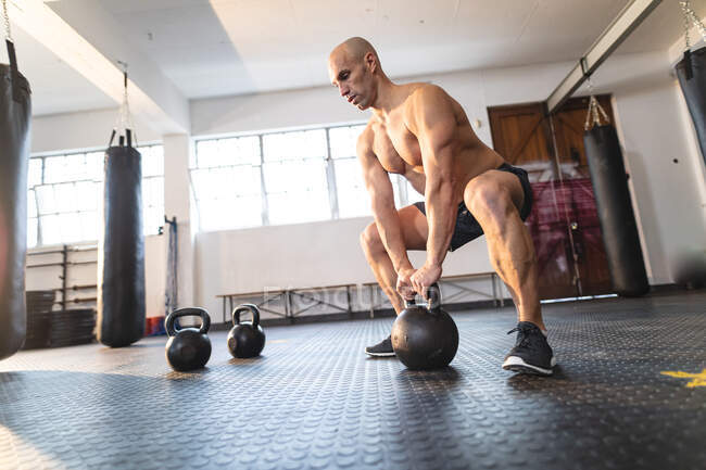 Homem caucasiano forte exercitando-se no ginásio, levantando pesos. treinamento cruzado de força e aptidão para boxe. — Fotografia de Stock