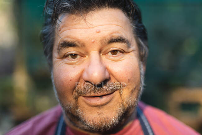 Портрет счастливого кавказского садовника, смотрящего в камеру в центре сада. специалист, работающий в питомнике бонсай, независимый садоводческий бизнес. — стоковое фото