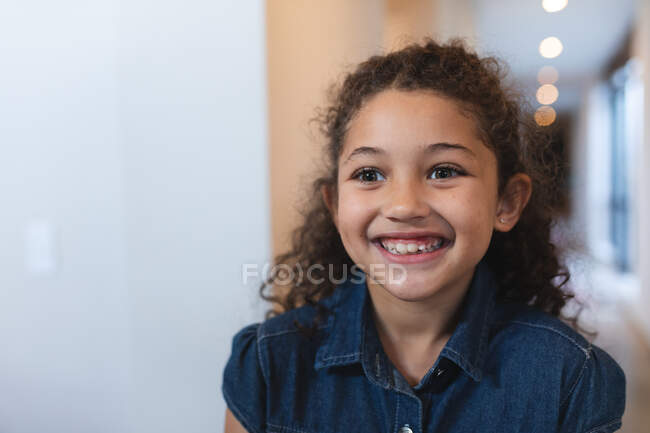 Porträt eines glücklichen Mischlingsmädchens, das in die Kamera blickt. Lebensstil und hochwertige Zeit zu Hause verbringen. — Stockfoto