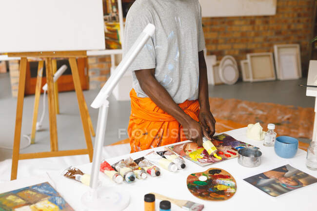 Африканский художник-американец работает в художественной студии. создание и вдохновение в студии живописи художников. — стоковое фото