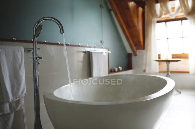 Interior of luxury bathroom and bath with running water. domestic lifestyle, enjoying leisure time at home. — Stock Photo