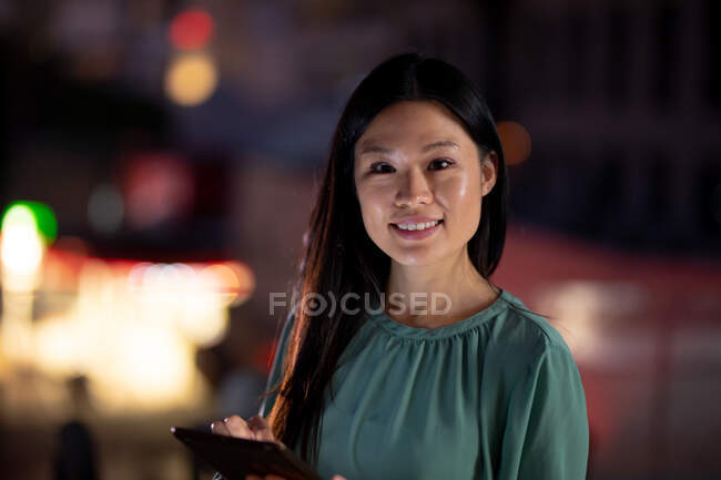 Retrato de una mujer de negocios que trabaja de noche usando una tableta. trabajar hasta tarde en los negocios en una oficina moderna. - foto de stock