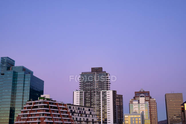 Moderne Hochhäuser im bebauten Geschäftsviertel der modernen Stadt mit Dämmerungshimmel. Modernes architektonisches Stadtbild. — Stockfoto