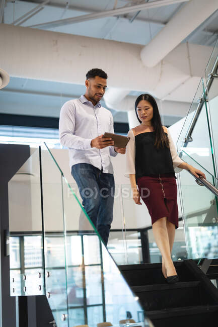 Разнообразные коллеги по бизнесу мужчины и женщины, использующие планшеты и разговоры. работа в бизнесе в современном офисе. — стоковое фото