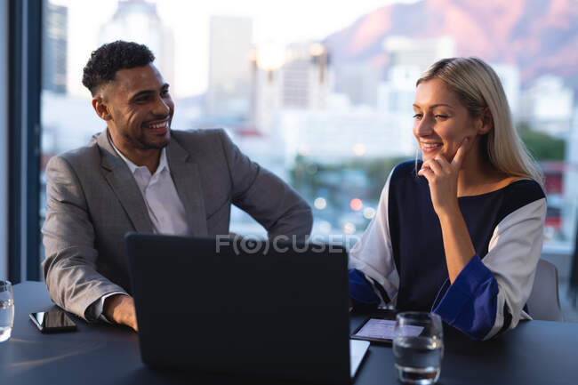 Двое разных коллег по бизнесу мужчин и женщин разговаривают и пользуются ноутбуком. работа в бизнесе в современном офисе. — стоковое фото