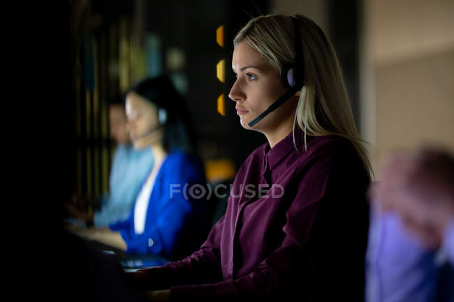 Kaukasische Geschäftsfrau, die nachts mit Headset arbeitet. spät arbeiten in einem modernen Büro. — Stockfoto