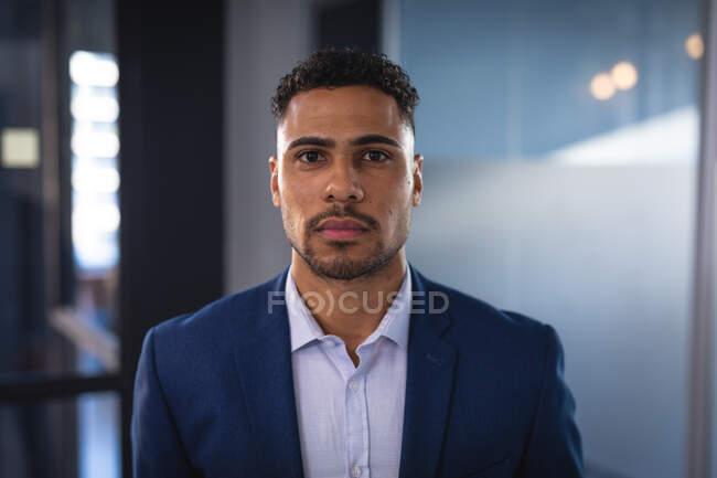 Portrait of mixed race businessman looking at camera. working in business at a modern office. — Stock Photo