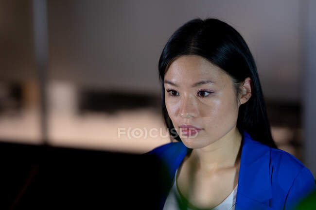 Donna d'affari asiatica che lavora di notte utilizzando il computer portatile. lavorare fino a tardi negli affari in un ufficio moderno. — Foto stock