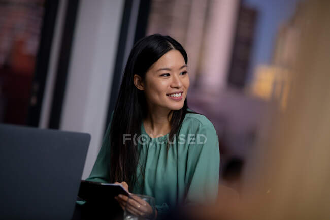 Donna d'affari asiatica che lavora di notte avendo incontro. lavorare fino a tardi negli affari in un ufficio moderno. — Foto stock