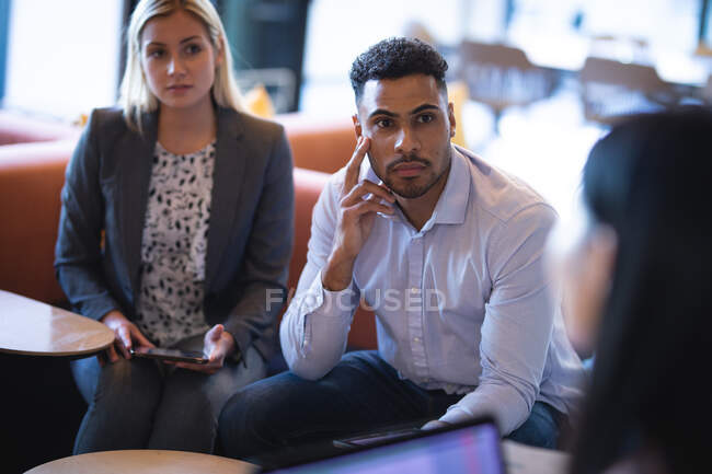 Diverso grupo de colegas de negocios que utilizan el ordenador portátil y tener una reunión. trabajar en un negocio en una oficina moderna. - foto de stock