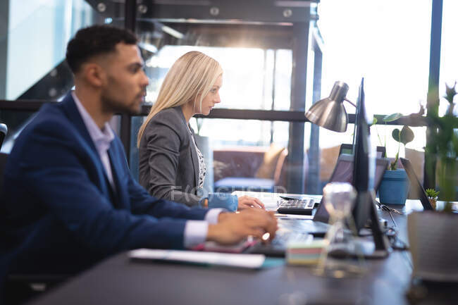 Різні чоловічі та жіночі бізнес-колеги працюють разом за столом, використовуючи ноутбук. робота в бізнесі в сучасному офісі . — стокове фото