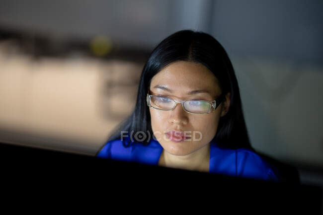 Азійська бізнесменка працює вночі за допомогою комп'ютера. Працював у сфері бізнесу в сучасному офісі.. — стокове фото