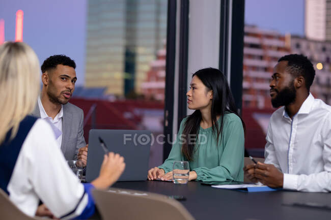 Grupo diverso de colegas de negócios que trabalham à noite tendo reunião. trabalhando até tarde em negócios em um escritório moderno. — Fotografia de Stock