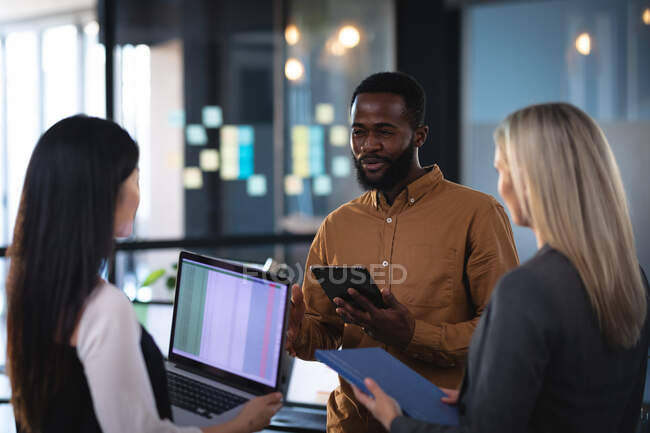 Diverse group of business colleagues using laptop and having meeting. working in business at a modern office. — Stock Photo