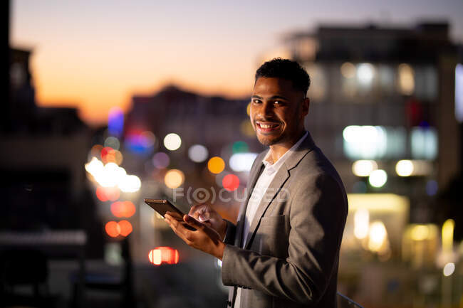 Retrato de hombre de negocios de raza mixta trabajando por la noche usando tableta. trabajar hasta tarde en los negocios en una oficina moderna. - foto de stock