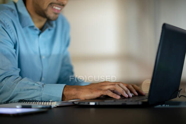 Homme d'affaires mixte travaillant la nuit avec un ordinateur portable. travailler tard dans les affaires dans un bureau moderne. — Photo de stock