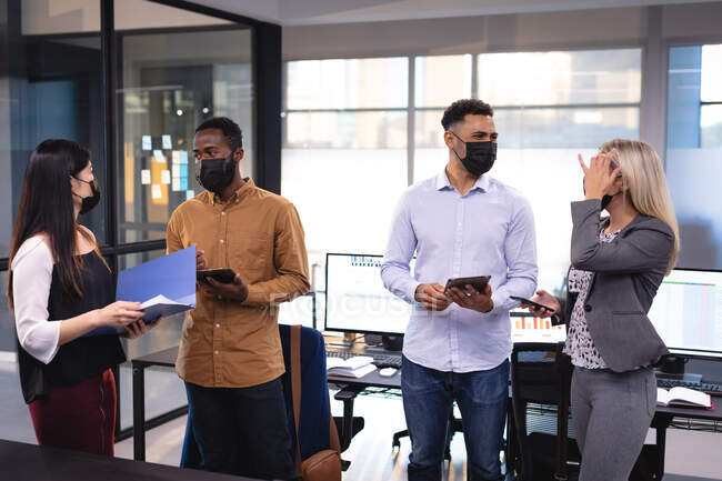 Grupo diverso de colegas de negócios usando máscaras faciais e tendo reunião. trabalhando em negócios em um escritório moderno durante coronavírus covid 19 pandemia. — Fotografia de Stock