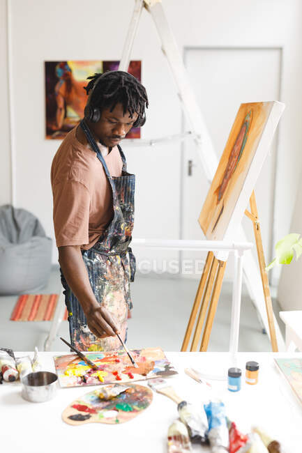 Afro-americano pintor masculino no trabalho pintura retrato sobre tela no estúdio de arte. criação e inspiração em um estúdio de pintura de artistas. — Fotografia de Stock