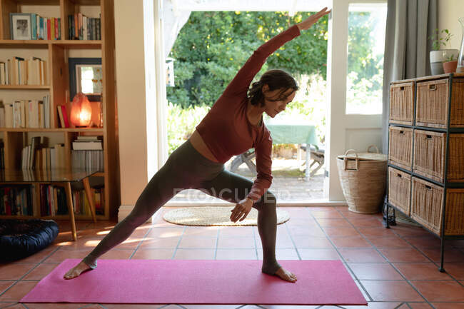 Caucasian woman in living room, practicing yoga, stretching. domestic lifestyle, enjoying leisure time at home. — Stock Photo