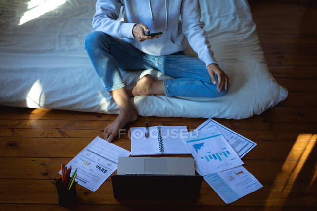 Женщина работает дистанционно с ноутбуком в солнечной спальне. здоровый образ жизни, удаленная работа из дома. — стоковое фото