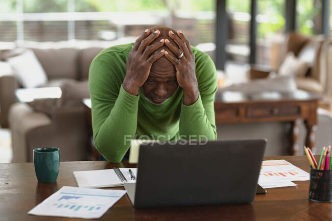 Stressed senior african american man in modern kitchen making video call. retirement lifestyle, spending time alone at home. — Stock Photo
