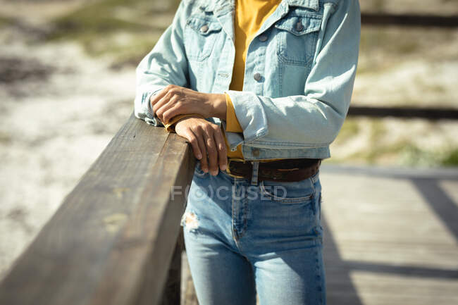 Woman standing on sunny day by seaside. healthy lifestyle, enjoying leisure time outdoors. — Stock Photo