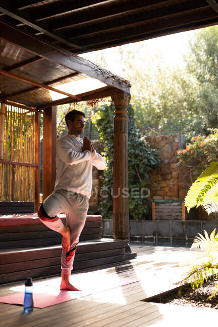 Homme caucasien portant des vêtements de sport et pratiquant le yoga sur tapis de yoga. passer du temps à la maison. — Photo de stock