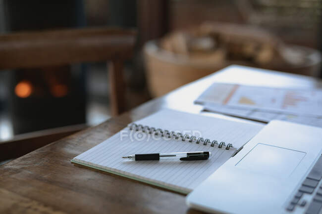 Abra el cuaderno con un bolígrafo y un portátil sobre la mesa. estilo de vida de jubilación, pasar tiempo solo en casa. - foto de stock