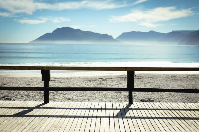 Promenade mit Bergen im Hintergrund an sonnigen Tagen am Meer. gesunder Lebensstil, Freizeit im Freien genießen. — Stockfoto