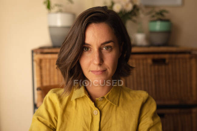 Portrait of smiling caucasian woman in living room looking at camera. domestic lifestyle, enjoying leisure time at home. — Stock Photo