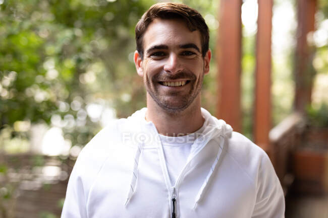 Portrait of happy caucasian man wearing sportswear and looking at camera. spending time off at home. — Stock Photo