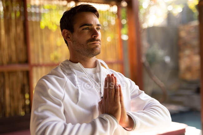 Caucasian man wearing sportswear and practicing yoga on yoga mat. spending time off at home. — Stock Photo