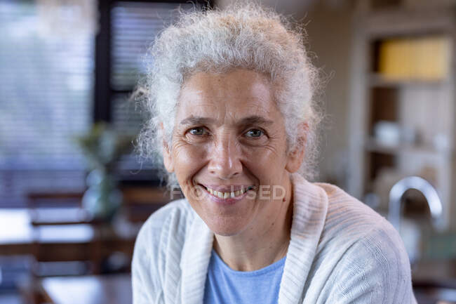 Retrato de mulher branca sênior sorridente na cozinha. estilo de vida aposentadoria, passar o tempo sozinho em casa. — Fotografia de Stock