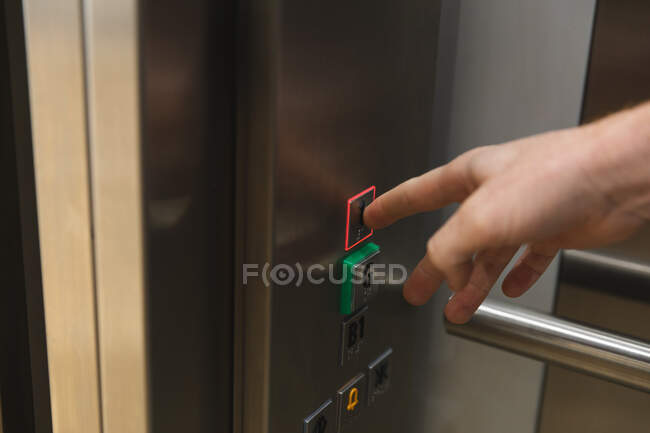 Main de l'entreprise masculine boutons touchants créatifs dans l'ascenseur. entrepreneurs créatifs indépendants travaillant dans un bureau moderne. — Photo de stock