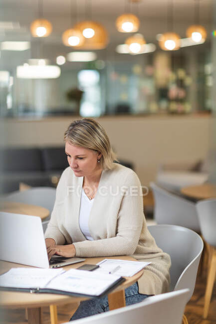Thoughtful caucasian female business creative using laptop at workplace cafeteria. independent creative business people working at a modern office. — Stock Photo