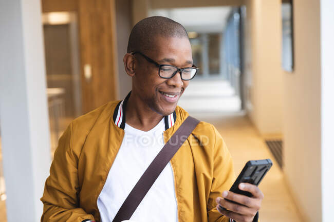 Smiling african american male business creative using smartphone. independent creative business people working at a modern office. — Stock Photo
